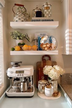 a coffee maker sitting on top of a counter next to a shelf filled with food