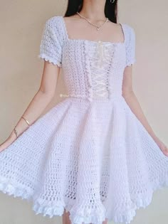 a woman wearing a white crochet dress