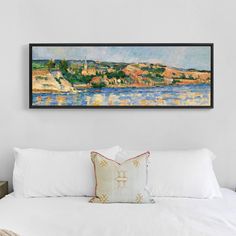 a painting hanging above a bed in a room with white sheets and pillows on it