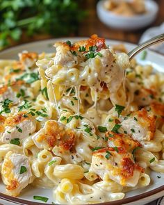 a fork full of macaroni and cheese with parsley on the top, in a bowl