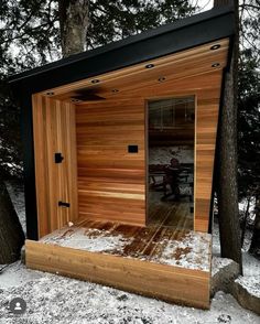 a sauna in the woods with snow on the ground