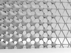 a black and white photo of a wall made out of circles with holes in the middle