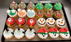 cupcakes with frosting and decorations are arranged on a tray