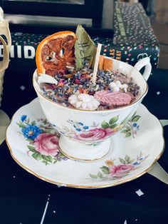 a tea cup filled with cereal and an orange slice sitting on top of a saucer