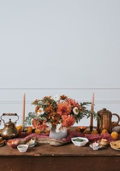 a table topped with lots of different types of food and flowers on top of it