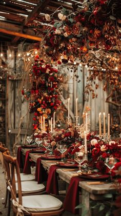 a long table with candles and red flowers on it is set for a formal dinner