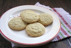 four cookies on a white plate with a red and green striped napkin