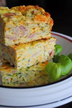 two slices of quiche stacked on top of each other in a plate with basil