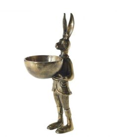 a metal rabbit holding a bowl on its back