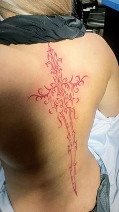 the back of a woman's upper body with a tattoo design on her lower back