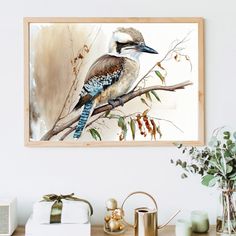 a bird sitting on top of a tree branch in front of a wall mounted painting