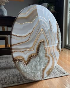 a large white and gold object sitting on top of a wooden floor