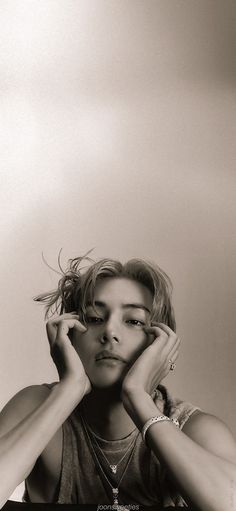 a black and white photo of a woman holding her hands to her face with one hand