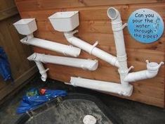 there are many white pipes attached to the side of a building with a sign on it that says can you pour the water through the pipes?