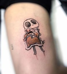 a person with a skull tattoo on their leg holding a small piece of bread in his hand