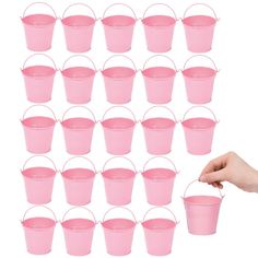 a hand holding a pink plastic bucket filled with lots of different sizes and colors on white background