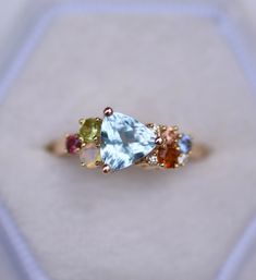 three different colored stones in a gold ring