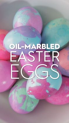 some colorful eggs in a white bowl with the words oil - marbled easter eggs