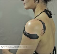 a woman with black ink on her shoulder