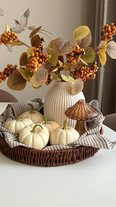 a basket filled with pumpkins sitting on top of a table