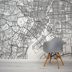 a grey chair sitting in front of a wall with a black and white map on it