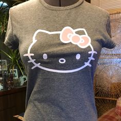 a hello kitty t - shirt is displayed on a mannequin