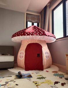 there is a mushroom house in the middle of the room with a red door and white polka dot roof