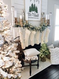 christmas stockings hung on the mantel in front of a fireplace decorated with greenery and candles