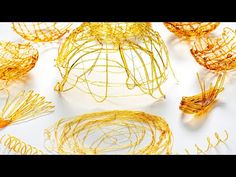 many yellow wire sculptures on a white surface