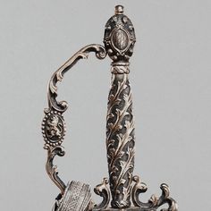 an ornately decorated silver vase sitting on top of a table