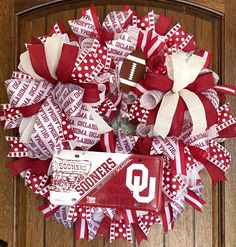 a wreath made out of red and white ribbon with a football on it