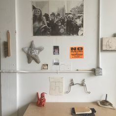 there is a desk with pictures on the wall above it and other items around it