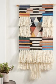 a multicolored rug hanging on the wall