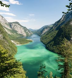 a lake surrounded by mountains with green water