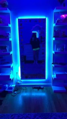 a person standing in front of a mirror with blue lights on it's sides