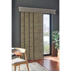 a dining room with a table and chairs next to a sliding glass door that has bamboo blinds on it