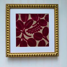 a red and gold framed artwork hanging on the wall