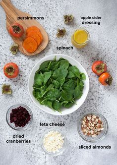 the ingredients to make this salad include spinach, carrots, cranberries, apples, almonds and other vegetables