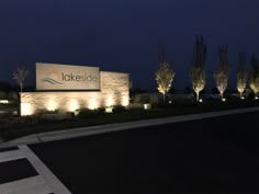 the entrance to lakeside at night with lights on and trees lit up in the background