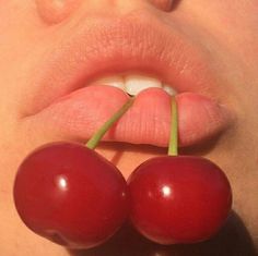 a woman's lips with two cherries sticking out of the top and bottom