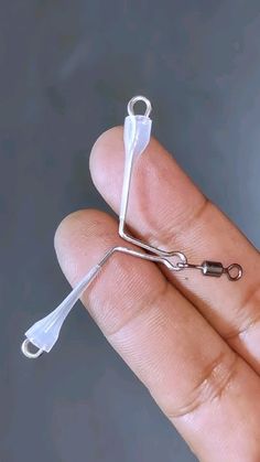 a pair of scissors being held in someone's hand with wire attached to it