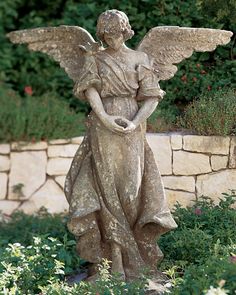 a statue of an angel standing in the grass