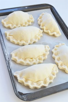 four uncooked dumplings on a baking sheet ready to go into the oven