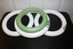 three white and green rings sitting on top of a black table next to each other