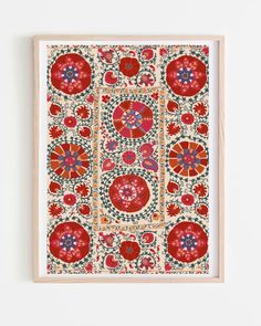 an art work with red and blue designs on white paper, framed in wood frame