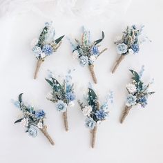 six small blue flowers are placed on top of each other in the shape of toothpicks