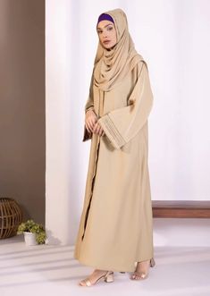 Abaya & hijab set for Women. Description : Abaya : Full length abaya in soft, drapey fabric. Button through front opening. V neckline. Full sleeves with diamanté and pleats detail. Material : Nidha Color: Beige Country : Made in Pakistan Elegant Solid Niqab For Eid, Elegant Niqab For Eid, Solid Long Thobe For Eid, Long Thobe For Eid, Modest Solid Color Floor-length Abaya, Modest Long Abaya For Eid, Modest Floor-length Abaya, Elegant Maxi Length Niqab For Eid, Elegant Long Niqab For Eid