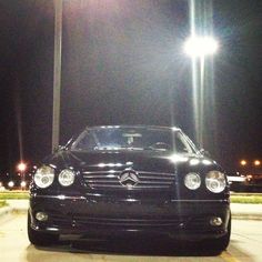 a black car parked in a parking lot at night