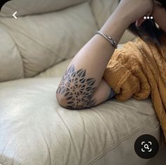 a woman sitting on top of a couch with her arm over her head