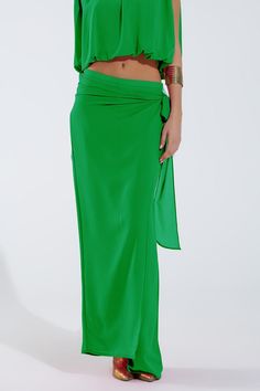 Introducing our Wide Green Pants Overlay Skirt, a stunning and versatile piece perfect for adding a touch of elegance to your party attire. This maxi-length overlay skirt features wide legs and a relaxed fit, providing both comfort and sophistication for any occasion.  Crafted from lightweight chiffon fabric, this overlay skirt drapes beautifully and flows with every movement. The knot detail at the side adds a chic and stylish touch, while the zip side closure ensures easy wear.  Perfect for parties or special events, this skirt can be paired with a variety of tops to create different looks. Made from 100% polyester with a polyester lining, it is durable and easy to care for, making it a practical choice for your wardrobe.  Our model is wearing size S, but the S-M-L sizing corresponds to